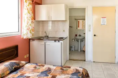 a bedroom with a bed and a sink and a kitchen at Aphrodite Apartments in Kallithea Rhodes