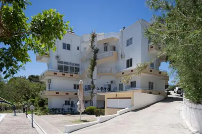 a large white building with trees in front of it at Aphrodite Apartments in Kallithea Rhodes