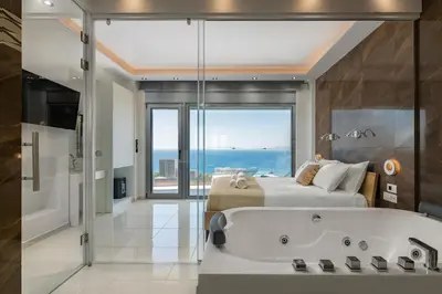 a bedroom with a large bed and a bath tub at Rhodes Skyline Suite with out Door Jacuzzi Sea View A2 in Ixia