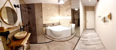 a bathroom with a tub and a sink and a mirror at Golden City Center Suites in Rhodes Town