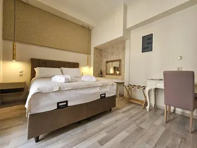 a bedroom with a bed and a desk and a piano at Golden City Center Suites in Rhodes Town
