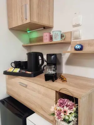 a kitchen counter with a coffee maker and flowers on it at Golden City Center Suites in Rhodes Town
