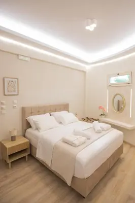 a white bedroom with a large bed with towels on it at Golden City Center Suites in Rhodes Town