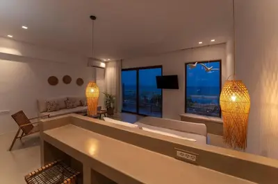 a large living room with a couch and a tv at Kohili Suite Stegna Beach in Archangelos