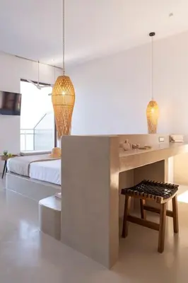 a bedroom with a bed and a table and a bench at Kohili Suite Stegna Beach in Archangelos
