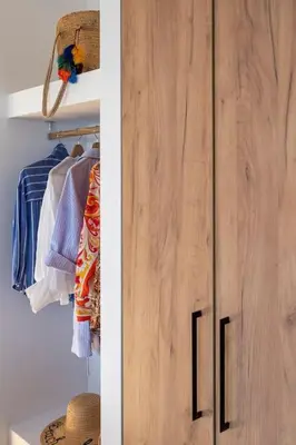 a closet with a wooden door in a room at Kohili Suite Stegna Beach in Archangelos