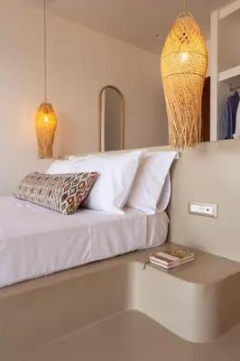a bed with white pillows on top of a room at Kohili Suite Stegna Beach in Archangelos