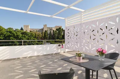 a patio with a table and chairs on a balcony at Castelo View Luxury apt in Rhodes Town