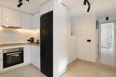 a kitchen with white cabinets and a black refrigerator at Castelo View Luxury apt in Rhodes Town