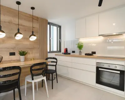 a kitchen with white cabinets and a table and chairs at Castelo View Luxury apt in Rhodes Town