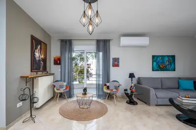 a living room with a gray couch and chairs at Atelier 71 in Rhodes Town