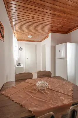 a dining room with a table and a refrigerator at Aneza in Kremasti