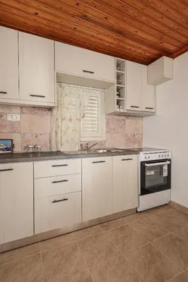 a kitchen with white cabinets and a sink and a window at Aneza in Kremasti
