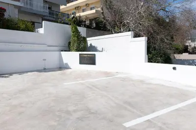 a parking lot in front of a white fence at K Luxury Apartment in Rhodes Town