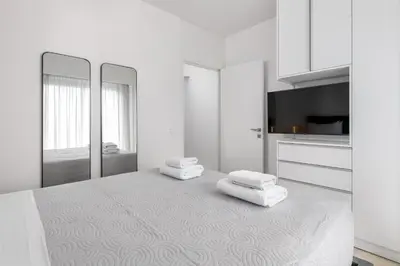 a white room with a bed with two towels on it at K Luxury Apartment in Rhodes Town