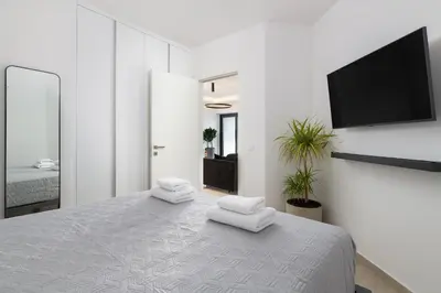 a white bedroom with a bed with towels on it at K Luxury Apartment in Rhodes Town
