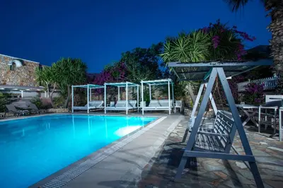 a swimming pool with a chair and a umbrella at Hotel Irini in Livadia