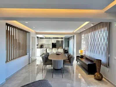 a dining room and living room with a table and chairs at Rhode Luxury Villa in Kalithies