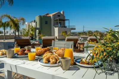 a table with plates of food and orange juice at Rhode Luxury Villa in Kalithies