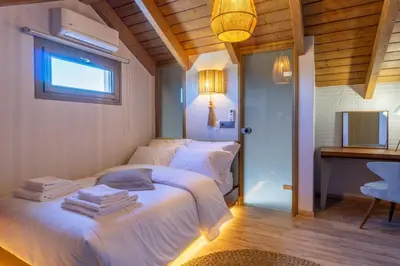 a bedroom with two beds and a desk and a window at Rhode Luxury Villa in Kalithies