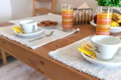 a wooden table with two cups and plates of food at Beachside Apartment-2 in Afantou