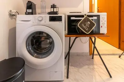 a washing machine and a sign on a table at Beachside Apartment-2 in Afantou