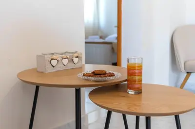a table with a glass of juice and cookies on it at Beachside Apartment-2 in Afantou