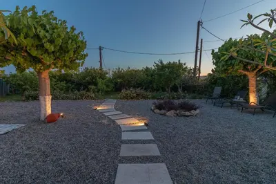 a garden with a pathway with a tree and lights at Beachside Apartment-2 in Afantou