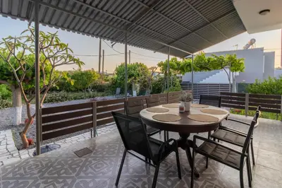 a table and chairs under an umbrella on a patio at Beachside Apartment-2 in Afantou