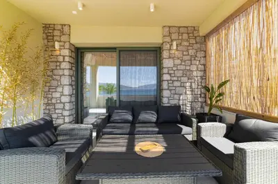 a screened in porch with couches and a table at Sirin Luxury Suites - 1st floor in Haraki