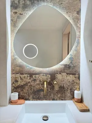 a bathroom with a round mirror above a tub at Sirin Luxury Suites - 1st floor in Haraki