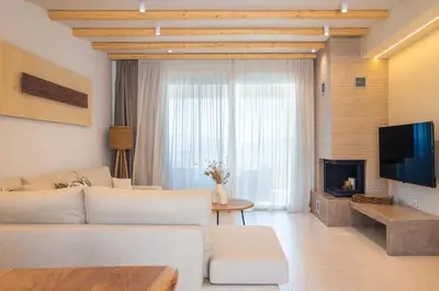 a living room with a couch and a tv at Sirin Luxury Suites - 1st floor in Haraki
