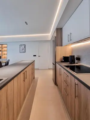 a kitchen with wooden cabinets and a counter top at AKTI city apartment in Rhodes Town