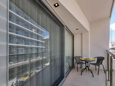 an apartment balcony with a table and chairs on it at AKTI city apartment in Rhodes Town