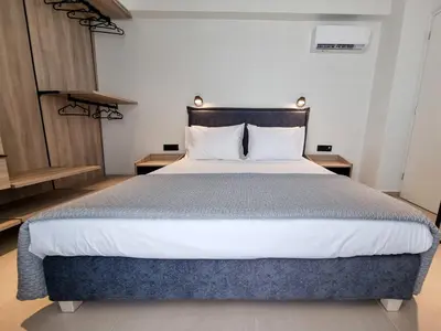a large bed in a room with two tables at AKTI city apartment in Rhodes Town