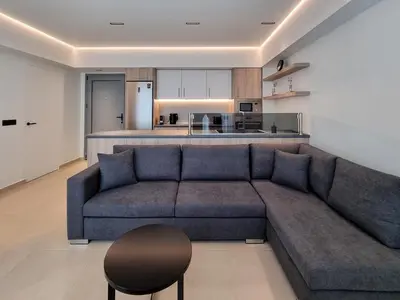 a living room with a blue couch and a kitchen at AKTI city apartment in Rhodes Town