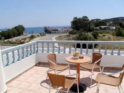 a patio with a table and chairs on a balcony at Lakis Apartments in Faliraki