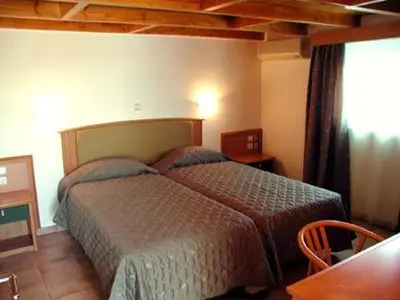 a bedroom with two beds and a table at Lakis Apartments in Faliraki