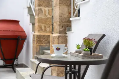 a small table with a coffee cup and flowers on it at Casa Tradizionale in Rhodes Town