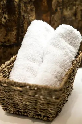 a basket filled with white towels on a table at Sirin Luxury Suites Groundfloor in Haraki