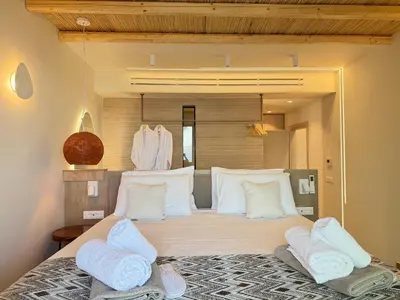 a bedroom with a large bed with white pillows at Sirin Luxury Suites Groundfloor in Haraki
