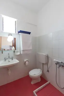 a bathroom with a toilet and a sink at Cozy Archangelos apartments with private parking in Archangelos