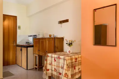 a kitchen with a table with a vase of flowers on it at Cozy Archangelos apartments with private parking in Archangelos