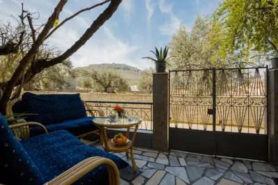 a patio with two blue chairs and a table at Cozy Archangelos apartments with private parking in Archangelos