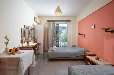 a bedroom with a bed and a desk and a table at Cozy Archangelos apartments with private parking in Archangelos