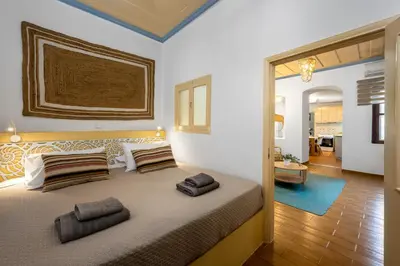 a bedroom with a large bed with two pillows on it at Lemon Tree Symi in Symi
