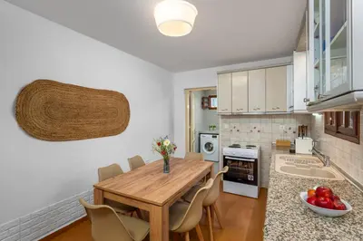 a kitchen with a wooden table and some chairs at Lemon Tree Symi in Symi