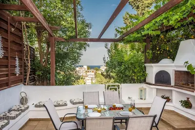 a patio with a table and chairs and a fireplace at Family Getaway Home in Rhodes Town