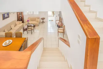 a staircase in a living room with a couch and chairs at Family Getaway Home in Rhodes Town