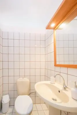 a white bathroom with a toilet and a sink at Family Getaway Home in Rhodes Town